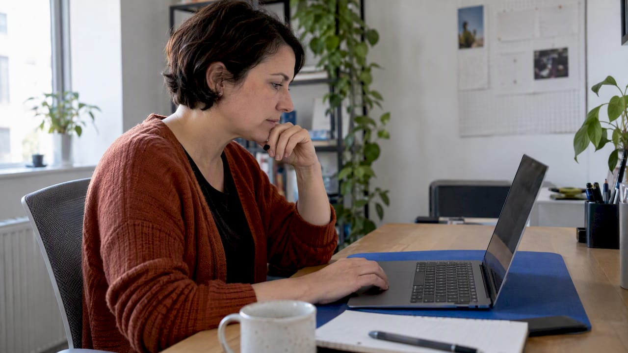 Business owner comparing CRM options at laptop