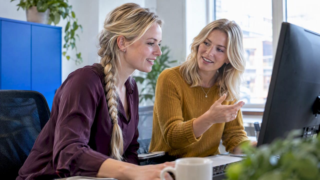 Two colleagues comparing CRM software options